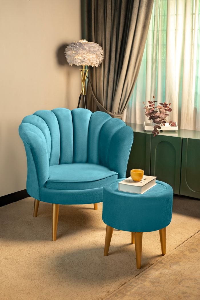 A sophisticated teal chair and ottoman in a stylish living room with soft lighting.